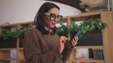 Businesswoman using smartphone in office.Business woman dressed casual clothes in office meeting room Professional female employee in glasses holding mobile phone. close up shoot low angle view