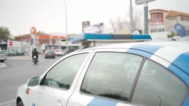 Yanıp sönen ışıkları olan polis arabası yolu kapattı. Beyaz polis arabasının çatısında yanıp sönen polis sinyallerini kapatın..
