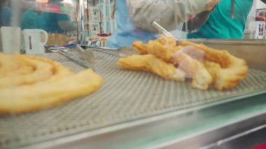 Taze churro yapımları. Sokak yemekleri satıcısı churros hazırlar hamuru makineye sıkıştırır. Churro İspanyol geleneksel çöreğidir..
