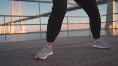 Boxer middle-aged womans dedication to becoming top-notch boxer, as she trains hard on the street and perfects her punches and jabs. Kickboxing training outdoors. Athletic female kickboxer outside