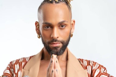 Patience, calmness and meditation concept. Peaceful relieved bearded young man practices yoga exercise, keeps hands in zen gesture, closes eyes, isolated on white background, controls his emotions