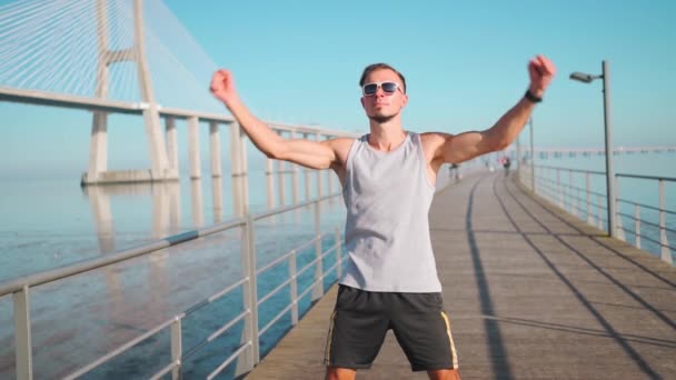 慢跑者在慢跑前热身运动 运动员伸展身体和胸部 然后站在夏天的蓝天背景上进行户外运动训练 — 图库视频影像