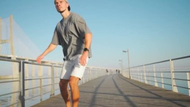 Briç yaz gününde kaykaya binen bir adam. Yetişkin erkek kaykaycılar kaykay sürmekten hoşlanırlar. Millenial hipster, uzun pano ön görüntüsünde.