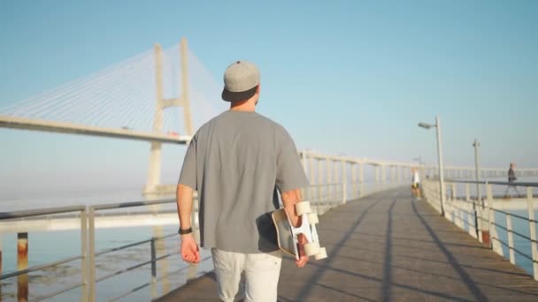 Hombre Caminar Con Monopatín Puente Día Verano Cerca Del Océano — Vídeos de Stock