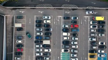 Otoparkın park alanındaki geniş hava manzarasını hızlandırın. Alışveriş merkezinin yakınındaki otoparkta araç yerleri ve yönleri için çizgiler ve işaretler var.