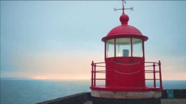 Deniz feneri lambası odası Nazare, Portekiz mavi gökyüzü ve deniz arka planı dramatik ruh hali, Atlantik Okyanusu 'ndaki eski deniz fenerinin akşamüstü çekilmiş görüntüleri.