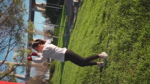 Kvinnans Träningsbenspark Klädda Huvhänder Inlindade Röda Boxningsband Parken Kvinnliga Idrottare — Stockvideo