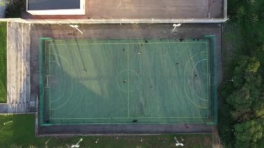 İnsanlarla oynayan yapay plastik kaplı mini futbol sahasının hava aracı görüntüsü. Güneşli yaz günü insansız hava aracı manzaralı şehirde halka açık bir spor alanı. Portekiz