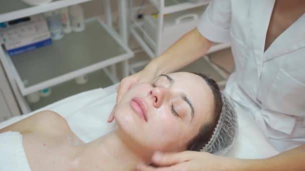 Massagetherapeut Aanbrengen Crème Masseren Gezicht Nek Aan Vrouw Cosmetologie Kast — Stockvideo