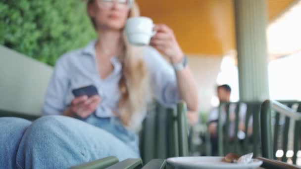 Mujer Sosteniendo Smartphone Sus Manos Bebiendo Café Sentado Verano Café — Vídeos de Stock