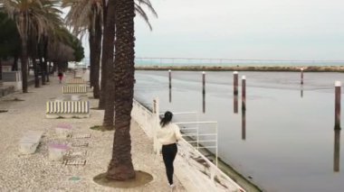 Kafkasyalı bir kadının halka açık bir parkı işletirken çekilmiş videosu. Spor giyimde tek başına dışarıda egzersiz yapan aktif bir koşucu. Sağlıklı yaşam tarzı kavramı. Sonbahar günü 
