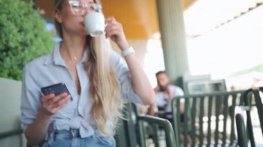 Güzel gülüşü olan, kafede dinlenirken cep telefonundan iyi haberler okuyan, kafede dinlenirken elinde cep telefonu tutan, mutlu, beyaz bir kadın.. 