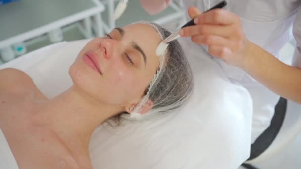 Профессиональный Косметолог Делает Массаж Лица Кисточками Лежащей Женщины Спа Салоне — стоковое видео