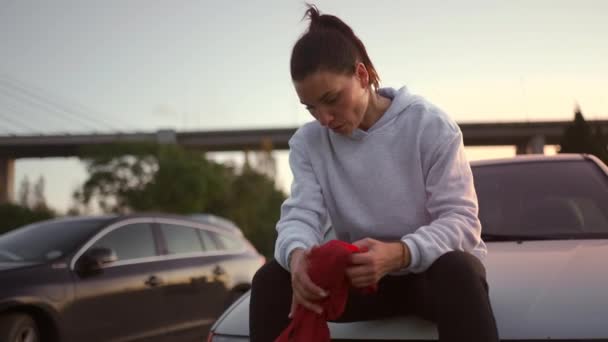 跆拳道女子坐在车上 晚上外出练完拳后休息 她手里拿着红色的拳击带 之前她已经把它拿走了 她累了 但很高兴 — 图库视频影像