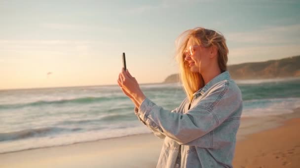 Жінка Стоїть Океанському Пляжі Заході Сонця Знімає Відеоблог Під Час — стокове відео