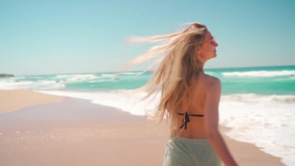 여름휴가를 즐기는 여자가해 파도타기를 즐기고 선글라스 비키니 반바지를 해변을 거닐고 — 비디오