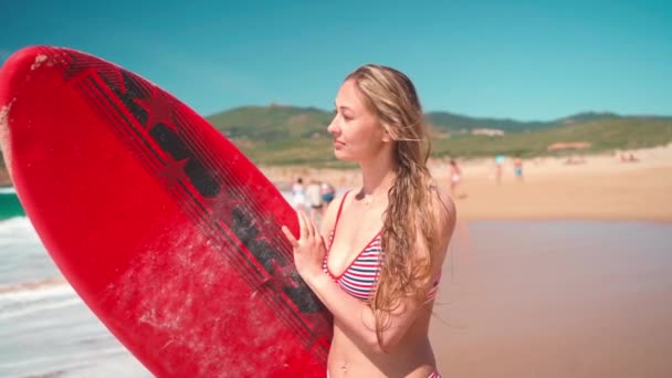 Привлекательная Серфингистка Полосатом Купальнике Отдыхает После Занятий Серфингом Стоя Пляже — стоковое видео