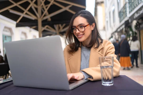 Szczęśliwa Studentka Freelancer Okularach Pomocą Laptopa Siedzi Przy Stole Kawiarni Zdjęcie Stockowe