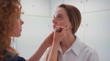 Makyöz, dudaklarında kalıcı dövme olması için kalemle işaret bırakır. Kalıcı makyaj dövmesi. Profesyonel makyaj ve cilt bakımı kozmetolojisi