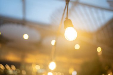 Geceleri turuncu ampul dekoru. Kablodan arka bahçeye sarkan ampuller