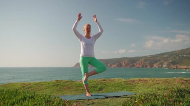 Gammal Kvinna Utövar Yoga Stranden Stående Trädet Poserar Vrikshasana Njuter — Stockvideo