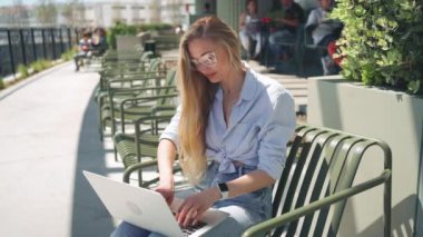 Uzaktan kumandalı iş ya da internet eğitiminde çalışmak, dizüstü bilgisayar kullanmak, notlar almak, gün içinde ofis terasında açık havada çalışmak. Çevrimiçi iş, genç profesyonel iş yeri