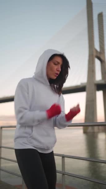 선수는 훈련하기 근육을 데우는 후디를 입혔습니다 Kickboxer 여자는 부두에 운동에 — 비디오