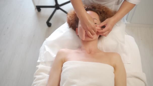 Massagetherapeut Die Gezichtsmassage Aan Vrouw Kosmetologie Kliniek Schoonheidsspecialiste Die Huidverzorging — Stockvideo