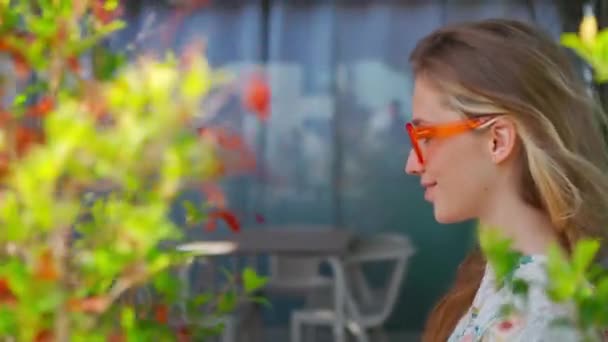테라스 카페에서 프로필 매력적인 여자의 클로즈업 초상화 오렌지 안경을 카메라에 — 비디오
