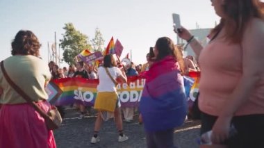 Lizbon, Portekiz. 17 Haziran 2023: Onur Yürüyüşü sırasında posterler, pankartlar, gökkuşağı bayraklarıyla geçit töreni. İnsanlar akıllı telefonlardan Gurur Yürüyüşü aktivistini filme alıyor. LGBTQ 'yu destekleyen mutlu ve özgür insanlar