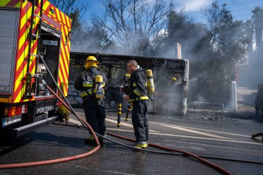 Portugal, Odivelas 07 September 2022 Rescue Team of Firefighters Arrive on the Car Crash fired passenger bus Traffic Accident Scene. Firemen fire department fight with fire on road. Accident disaster