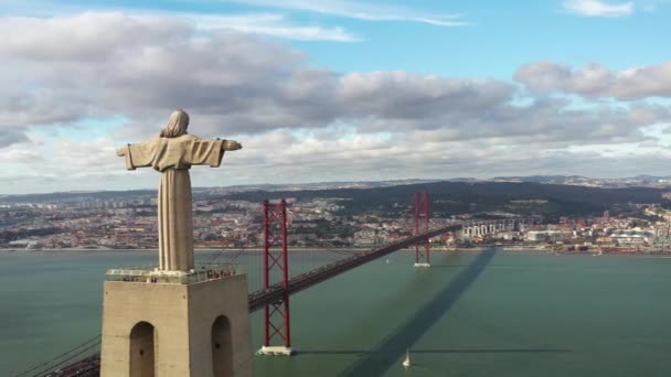 无人机围绕着巨大的雕塑基督圣地飞行 俯瞰着葡萄牙首都里斯本和横跨塔加斯河的阿布里尔桥25号 葡萄牙里斯本的地标和基础设施 — 图库视频影像