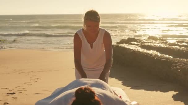 직업적인 안마사는 일몰에 바닷가에 편안한 여자를 트리트먼트 건강한 라이프 스타일과 — 비디오