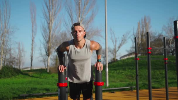 Açık Havada Triseps Egzersizi Için Paralel Barlar Kullanan Bir Adam — Stok video