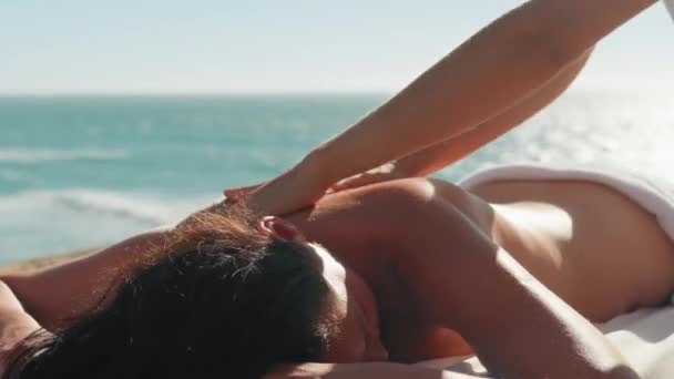 服装女用手工操作 手部有白色的指甲 在海滩上按摩女性 背景为绿松石色 暑假期间 女客户在海滩上享受身体和皮肤护理 — 图库视频影像