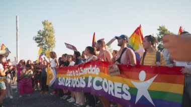 Lizbon, Portekiz. 17 Haziran 2023: LGBTQ cinsel eşitlik ve insan haklarına destek yürüyüşü. Gökkuşağı bayrakları ve sancaklarıyla neşeli insanlar. Onur Yürüyüşü 'nde LGBTQ eylemcileri