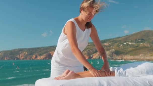 Blond Vrouwelijk Masseur Geven Benen Massage Client Liggend Massage Tafel — Stockvideo
