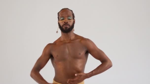 ポジティブなアフリカ系アメリカ人は白い背景に隔離された明るいメイクアップダンスを持つゲイの男性をひげました プライドと個性の感覚を表現しています 人格の多様性 — ストック動画