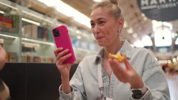 Markette Portekiz Tatlısını Yerken Akıllı Telefon Kullanan Genç Güzel Bir — Stok video