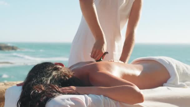 Professionell Kvinnlig Massageterapeut Använder Sten Enhet Massage Klienter Tillbaka Stranden — Stockvideo