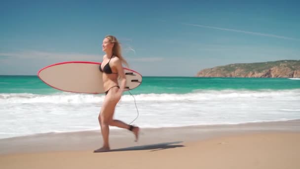 Vista Lateral Mujer Alegre Bikini Llevando Tabla Surf Corriendo Playa — Vídeo de stock