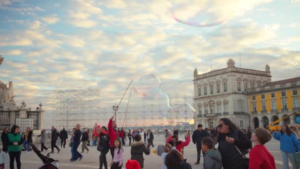 葡萄牙 里斯本 2023年12月25日孩子们在里斯本商业广场享受肥皂泡表演 孩子们想抓住空气中飘扬的气泡 街头表演者制造肥皂泡 — 图库视频影像