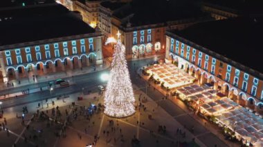Ticaret Meydanı 'nın hava insansız hava aracı görüntüleri Lizbon' da Noel gecesi aydınlatıldı ve süslendi. Noel ağacı ve Avrupa kenti turistleri kalabalıklaştı.