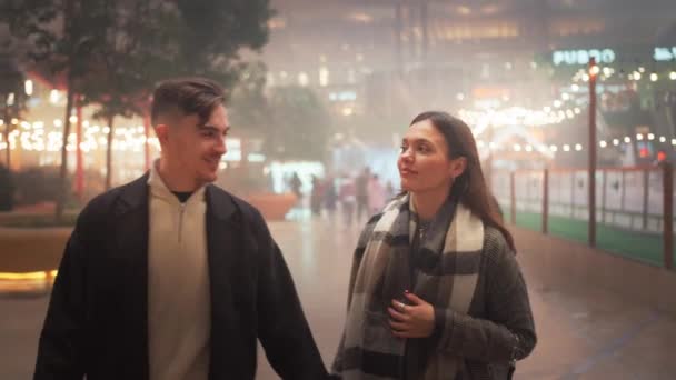 Boldog Fiatal Pár Divatos Ruhákban Beszélgetnek Miközben Gyalogolnak Karácsony Este — Stock videók