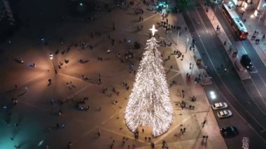 Lizbon 'da Noel ağacını aydınlatan hava manzarası Ticaret Meydanı' nda, Noel ağacında ve Avrupa şehrinde turistlerin kalabalık olduğu yerlerde.