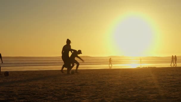 2024年2月18日 葡萄牙Carcavelos 日落时分 孩子们在海滩踢足球 孩子们在海滩上玩球的轮廓 慢动作 — 图库视频影像