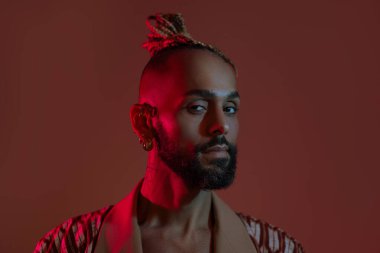 Retro dalga ya da sentetik dalga portresi ciddi bir Afro-Amerikan erkek stüdyo çekimi tarzında. Renkli parlak neon ışıklarla poz veren yüksek moda erkek model. Sanat tasarımı konsepti