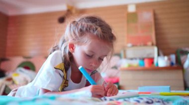 Küçük kız kalemle çizer ya da günlük tutar. Çocuk öğrenme ve ödev yapma. Evde ders çalışma. Yatağa yat. 