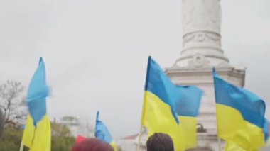 Ukraynalı erkek ve kadın mavi sarı bayraklı Lizbon sokaklarında Ukrayna 'daki savaş ve Rus işgalini protesto ediyorlar. Avrupa kentinden Ukrayna 'ya destek