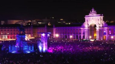 Lizbon, Portekiz 31 Aralık 2023 Havai fişek gösterisi Lisbon 'daki Ticaret Meydanı' nı gece aydınlatıyor. Portekiz, Lizbon 'da yeni yıl boyunca düzenlenen inanılmaz havai fişek gösterisini bir grup turist izliyor.